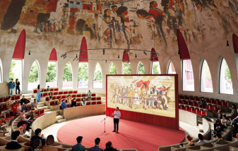 A mural from a local artist adorns the ceiling inside the agora